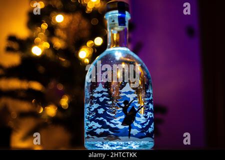 Ballerina dancing inside a snowy bottle with Christmas tree background Stock Photo