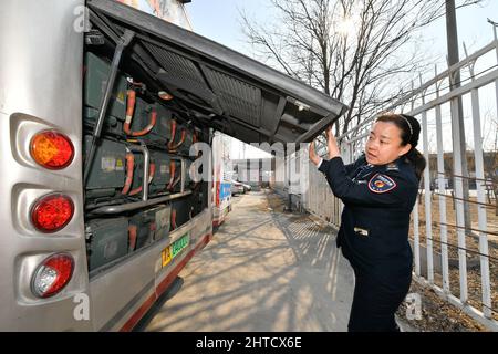 (220228) -- TIANJIN, Feb. 28, 2022 (Xinhua) -- Wang Yan checks the batteries of her bus at a bus stop in north China's Tianjin, Feb. 24, 2022. Tianjin bus driver Wang Yan is a National People's Congress (NPC) deputy. Since taking on her duties in 2018, Wang has continued to submit suggestions to the NPC, covering a variety of areas, such as transportation and health care. As a bus driver, she makes the most of her job, listening to her passengers' opinions, while formulating suggestions that can have an influence on government policies. This year is the last year of her term of NPC deputy Stock Photo