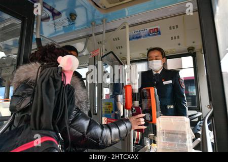 (220228) -- TIANJIN, Feb. 28, 2022 (Xinhua) -- Wang Yan (R) checks a passenger's health code and body temperature aboard a bus in north China's Tianjin, Feb. 24, 2022. Tianjin bus driver Wang Yan is a National People's Congress (NPC) deputy. Since taking on her duties in 2018, Wang has continued to submit suggestions to the NPC, covering a variety of areas, such as transportation and health care. As a bus driver, she makes the most of her job, listening to her passengers' opinions, while formulating suggestions that can have an influence on government policies. This year is the last year Stock Photo