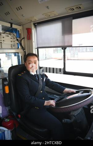 (220228) -- TIANJIN, Feb. 28, 2022 (Xinhua) -- Wang Yan poses for a photo aboard a bus in north China's Tianjin, Feb. 24, 2022. Tianjin bus driver Wang Yan is a National People's Congress (NPC) deputy. Since taking on her duties in 2018, Wang has continued to submit suggestions to the NPC, covering a variety of areas, such as transportation and health care. As a bus driver, she makes the most of her job, listening to her passengers' opinions, while formulating suggestions that can have an influence on government policies. This year is the last year of her term of NPC deputy, Wang will put Stock Photo