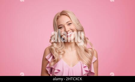 Charming Blonde Woman Smiling To Camera Posing Over Pink Background Stock Photo