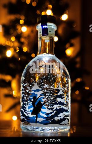 Vertical shot of ballerina dancing inside a snowy bottle with Christmas tree background Stock Photo