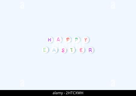 Happy Easter. Quote made of white round beads with colorful letters on a blue background. Stock Photo