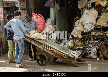 Closeup shot of three Indian men with masks showing something on the