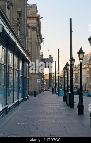 Old lamp posts furnish the footpath looking down Grey Street towards the Theatre Royal in Newcastle's city centre. Stock Photo