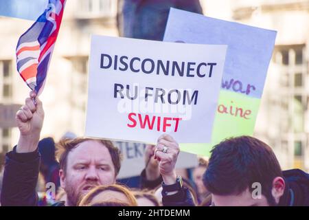London, UK. 24th February 2022. A protester calls for Russia to be disconnected from the SWIFT payment system. Demonstrators gathered outside Downing Street in protest against the Russian invasion of Ukraine, and called on the UK Government to help Ukraine and place additional sanctions on Russia. Stock Photo