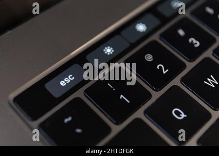 Close-up shot of the Escape key on touch bar of MacBook Pro laptop Stock Photo
