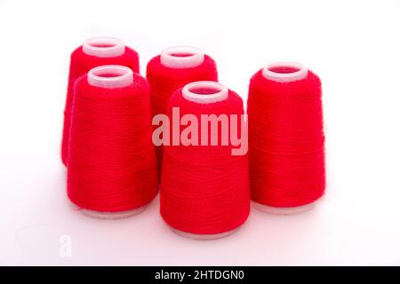 Red spool of thread isolated on white background. Skein of woolen threads. Yarn for knitting. Materials for sewing machine. Coil Stock Photo
