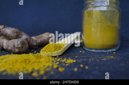 A closeup shot of Indian sulfur with a wooden spoon on a dark blue background Stock Photo