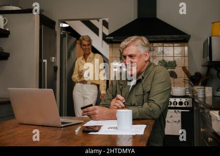 Caucasian male pensioner shopping online using credit card Stock Photo