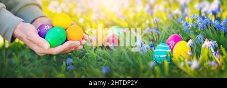 Human hands holding colourful vivid easter eggs Stock Photo