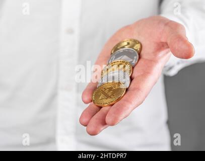 Businessman hand closeup holding cryptocurrency. Bitcoin, ethereum, litecoin. Mining and blockchain technology concept. High quality photo Stock Photo