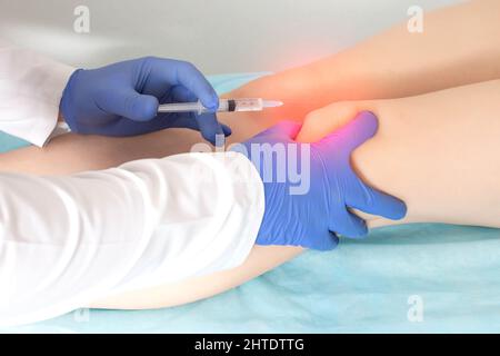 The doctor makes an injection of platelet-rich plasma, autostimulation of the regenerative processes of the joints. Stock Photo