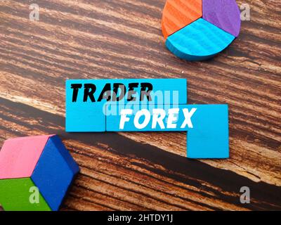 Colorful puzzle with text "TRADER FOREX" on a wooden background - business concept Stock Photo