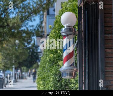 Los Angeles, CA, USA - February 25, 2022: Close up of a traditional Barber’s Pole in front of a barber shop in Los Angeles, CA. Stock Photo