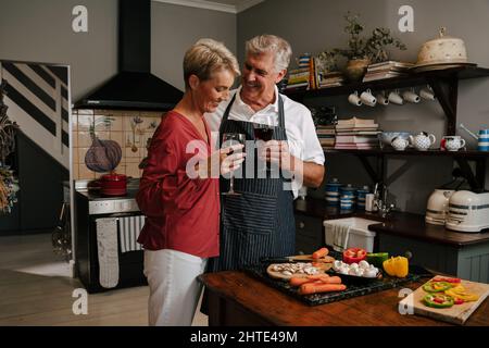 Caucasian elderly couple embracing while cooking in kitchen  Stock Photo