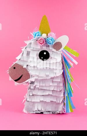 Handmade colorful Unicorn Piñata on pink background Stock Photo