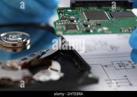 Male technician hold computer details, try to fix or collect device, dvd disc Stock Photo