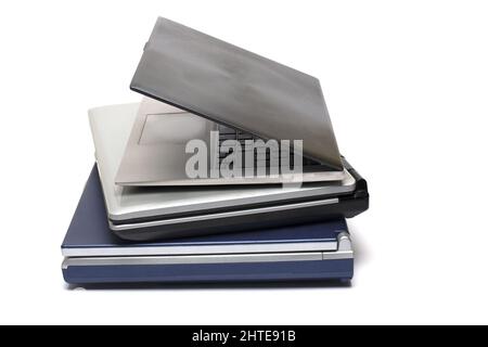 Close up of three stacked notebooks of different generations from old and heavy to modern and ultra light on white background concept development and Stock Photo