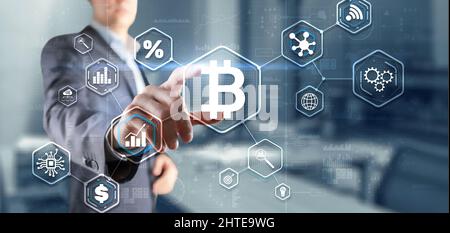 Man clicks on a virtual screen bitcoin icon. Stock Photo