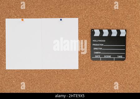 Cork board background with a cinema clapboard and two white empty papers  Stock Photo