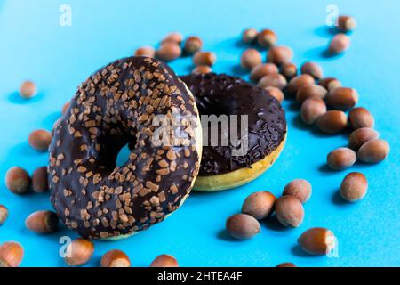 Donut with hazelnuts on a blue background, close up Stock Photo