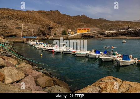 fishing boats line up in the calm sea of the natural harbour of puerto de la aldea gran canaria Stock Photo