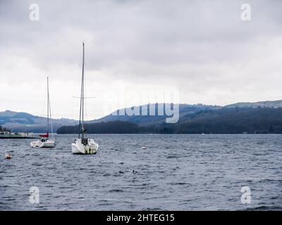 Two Sailing boats moored on Windermere Lake in the Lake District, UK, on a cold and rainy day Stock Photo