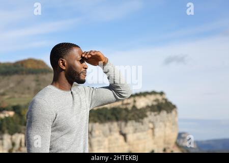 Side view portrait of a man with black skin contemplating with hand on forehead Stock Photo