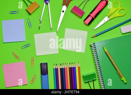 A top view of stationery isolated on a green background. Stock Photo