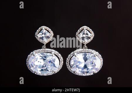 A close-up shot of diamond earrings isolated on a black background Stock Photo