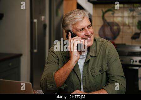 Caucasian senior male chatting on cellular device  Stock Photo