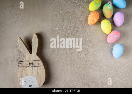 rabbit and colored easter eggs on a gray background, copy space Stock Photo