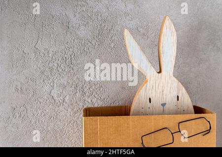 easter wooden bunny peeking out of cardboard box, copy space Stock Photo