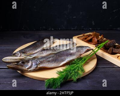 Sun dried fish, salted smelts over wooden background Stock Photo