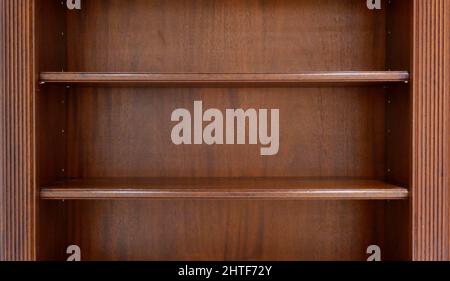 Dark brown empty wooden book shelves with space for copy Stock Photo
