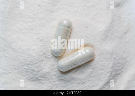 collagen in tablets and powder on wooden white background. Stock Photo