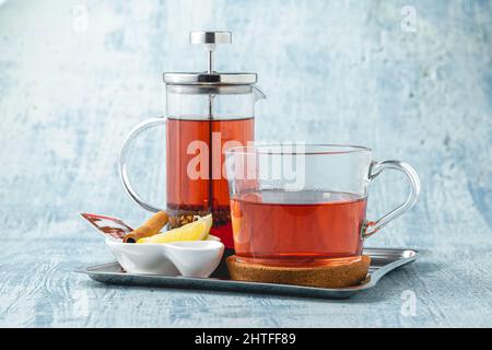 Hot winter tea served with a french press on a wooden table Stock Photo