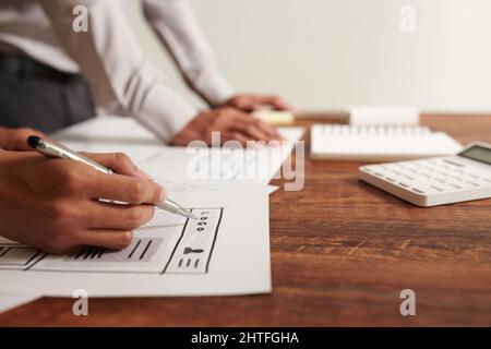 Hands of UI designer drawing wireframe of website or mobile application Stock Photo