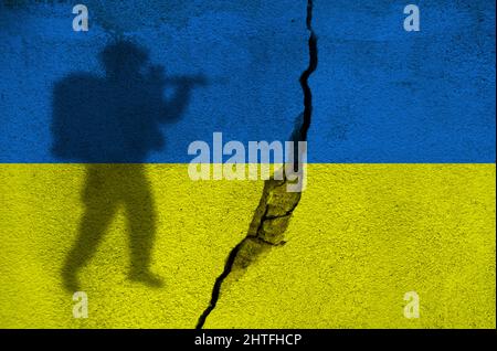Silhouette of soldier on Ukrainian flag painted on the cracked wall. War in Ukraine and Russian conflict concept Stock Photo