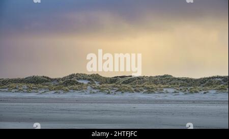 Stormy clouds hanging over the dunes on the island of Ameland at sunset Stock Photo