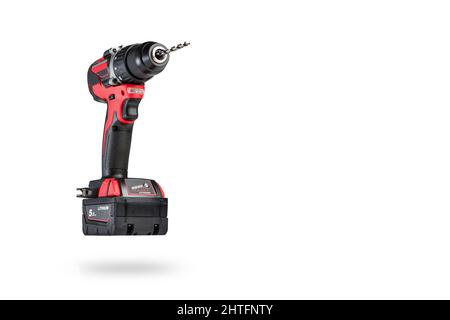 cordless tool isolated on white background. Cordless screwdriver with a drill inserted into the chuck and an extra battery on a white background. Stock Photo