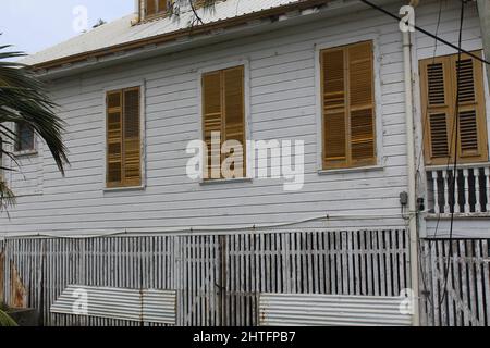 BELIZE CITY, BELIZE - SEPTEMBER 24, 2016 traditional wooden houses with yellow louvered windows in downtown Belize City Stock Photo
