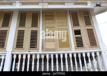 BELIZE CITY, BELIZE - SEPTEMBER 24, 2016 traditional wooden houses with yellow painted louvered windows in downtown Belize City Stock Photo