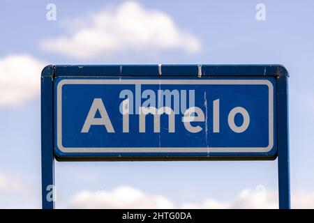 Traffic sign denoting that you are about to enter a residential area in which speed limits are in place with fluffy clouds in clear sky behind Stock Photo