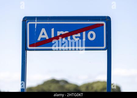 Traffic sign denoting that you are about to enter a residential area in which speed limits are in place with fluffy clouds in clear sky behind Stock Photo