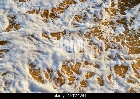 Brown sea water with white froth Stock Photo