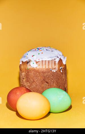 Close-up of colored Easter eggs and kulich on a yellow background. With a space to copy. High quality photo Stock Photo