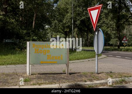 Traffic sign warning for a priority road and board pointing to a recreational park in Twente region. Stock Photo