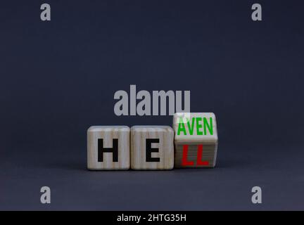 Hell or heaven symbol. Turned a wooden cube and changed the concept word Hell to Heaven. Beautiful grey table, grey background, copy space. Religion a Stock Photo